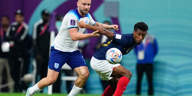 France's Kingsley Coman, right, and England's Luke Shaw battle for the ball during the World Cup quarterfinal match at the Al Bayt Stadium in Al Khor, Qatar, Dec. 10, 2022.