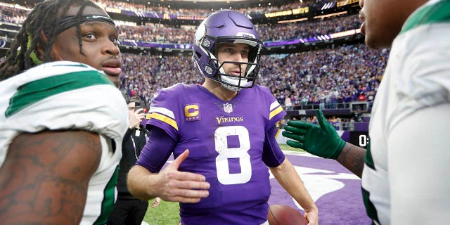 El mariscal de campo de los Minnesota Vikings, Kirk Cousins ​​​​(8), habla con los jugadores de los New York Jets después de un partido de fútbol americano de la NFL, el domingo 4 de diciembre de 2022, en Minneapolis.