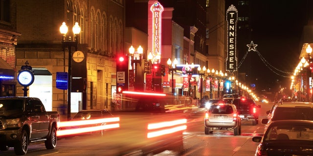 A night view of South Gay Street in downtown Knoxville with the neon sign of the Tennessee Theatre in the background.