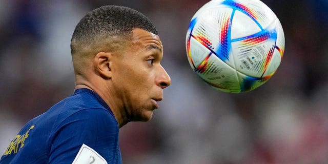 Kylian Mbappe heads the ball