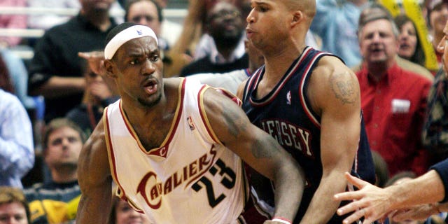 LeBron James (L) of the Cleveland Cavaliers posts up New Jersey Nets' Richard Jefferson during the fourth quarter of NBA play in Cleveland, Ohio, December 9, 2005.