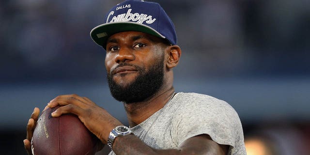 NBA player LeBron James of the Miami Heat throws a football at AT&T Stadium before the Sunday night game between the New York Giants and the Dallas Cowboys on September 8, 2013 in Arlington, Texas.