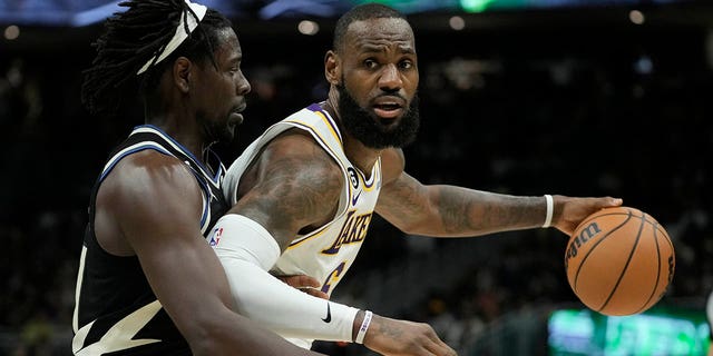 Los Angeles Lakers' LeBron James tries to get past Milwaukee Bucks' Jrue Holiday, Friday, Dec. 2, 2022, in Milwaukee.