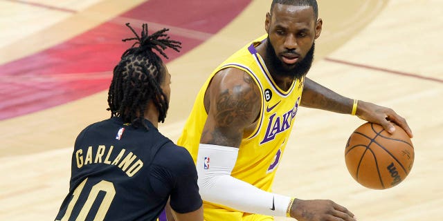 Los Angeles Lakers forward LeBron James is defended by Cleveland Cavaliers guard Darius Garland (10) during the first half of an NBA basketball game on Tuesday, December 6, 2022, in Cleveland.