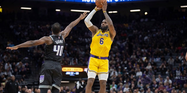 Los Angeles Lakers forward LeBron James, #6, shoots over Sacramento Kings forward Harrison Barnes, #40, during the second half in an NBA basketball game in Sacramento, California, Wednesday, Dec. 21, 2022. 