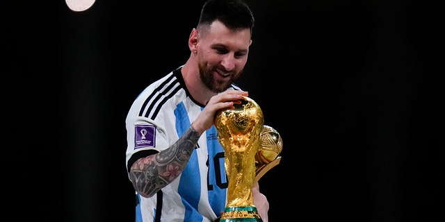Lionel Messi touches the World Cup trophy