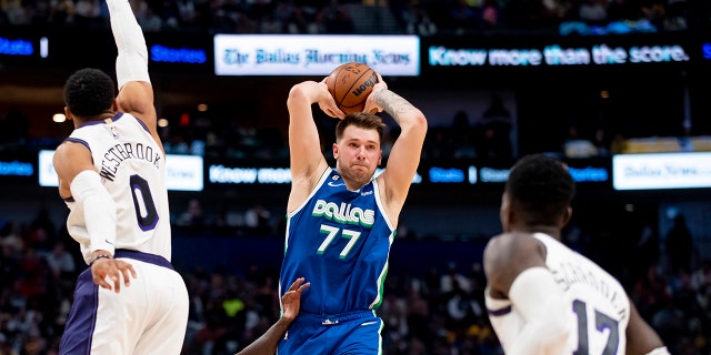 Dallas Mavericks guard Luka Doncic (77) prepares to pass the ball as Los Angeles Lakers guard Russell Westbrook (0) and Los Angeles Lakers guard Dennis Schroder (17) defend him in the second half of an NBA basketball game in Dallas, Sunday, Dec. 25, 2022.