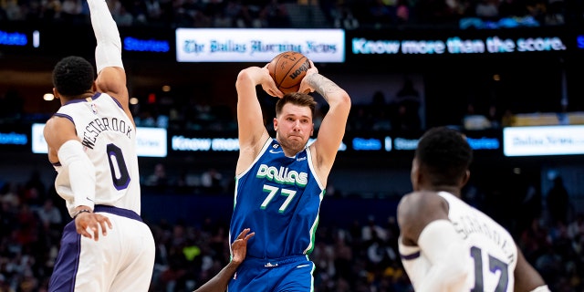 Dallas Mavericks guard Luka Doncic (77) prepares to pass the ball as Los Angeles Lakers guard Russell Westbrook (0) and Los Angeles Lakers guard Dennis Schroder (17) defend him in the second half of an NBA basketball game in Dallas, Sunday, Dec. 25, 2022. 