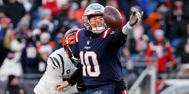 Vonn Bell, #24 of the Cincinnati Bengals, pressures Mac Jones #10 of the New England Patriots as he attempts a pass during the fourth quarter at Gillette Stadium on December 24, 2022, in Foxborough, Massachusetts.