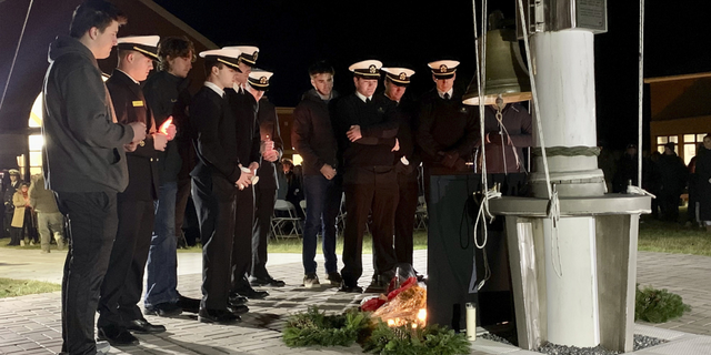 A group of Maine Maritime Academy students gather around a memorial set up on the school's Castine, Maine campus on Sunday, Dec. 11, to remember four students who died in a fiery weekend SUV crash.