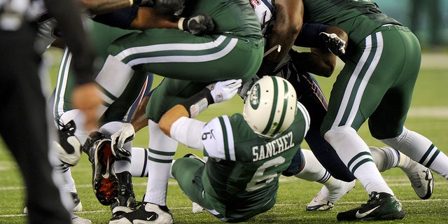 New York Jets quarterback Mark Sanchez #6 fumbles in the first half when the New York Jets played the New England Patriots. Sanchez smacks into lineman Brandon Moore's rear end and fumbles, leading directly to New England TD, part of 35-point 2nd quarter for the Patriots.