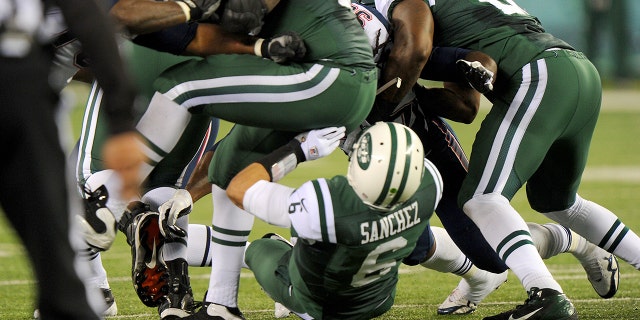 New York Jets quarterback Mark Sanchez #6 fumbles in the first half when the New York Jets played the New England Patriots. Sanchez smacks into lineman Brandon Moore's rear end and fumbles, leading directly to New England TD, part of 35-point 2nd quarter for the Patriots.