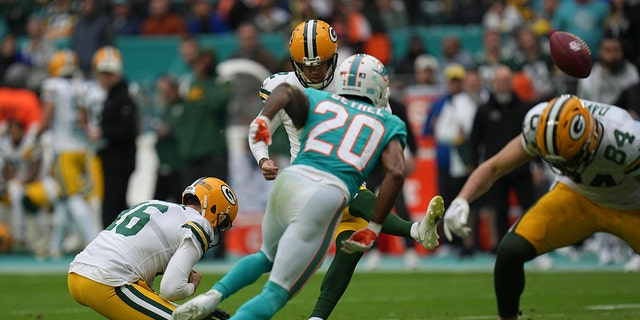 Green Bay Packers place kicker Mason Crosby (2) kicks a field goal, held by Green Bay Packers punter Pat O'Donnell (16) during the first half of an NFL football game, Sunday, Dec. 25, 2022, in Miami Gardens, Fla. 