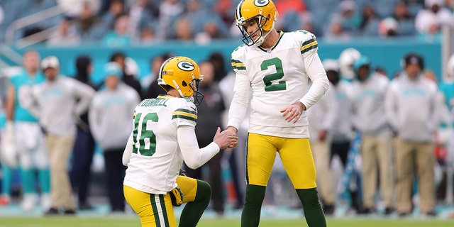Pat O'Donnell #16 of the Green Bay Packers high fives Mason Crosby #2 after a field goal during the second half of the game against the Miami Dolphins at Hard Rock Stadium on December 25, 2022 in Miami Gardens, Florida.
