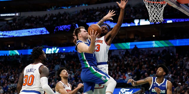 Luka Doncic of the Dallas Mavericks drives to the basket against Mitchell Robinson of the New York Knicks in the second half of their game at the American Airlines Center in Dallas on December 27, 2022.