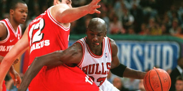 Michael Jordan (R), star des Chicago Bulls, se bat pour le ballon avec Dragan Tariach-Konstantinidis (L) d'Olympiakos Pirée lors des premières actions de leur match final du championnat McDonald's de 1997.