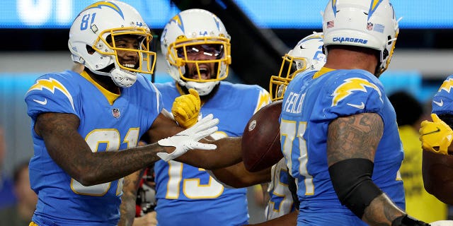 Mike Williams de Los Angeles Chargers es felicitado por sus compañeros de equipo después de anotar un touchdown en el primer cuarto de un juego en el SoFi Stadium en Inglewood, California, el 11 de diciembre de 2022.