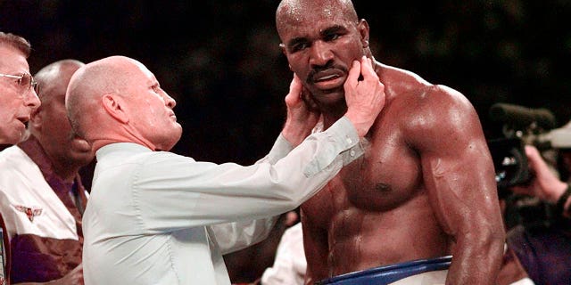 U-Evander Holyfield uhlolwe indlebe yakhe yesokudla unompempe uMills Lane ngemuva kokulunywa indlebe nguMike Tyson emzuliswaneni wesithathu womdlalo wabo wesibhakela we-WBA heavyweight ngoJuni 28, 1997, eLas Vegas.