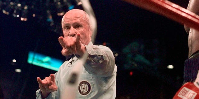 Unompempe uMills Lane ukhombisa ukuncishiswa ngamaphuzu amabili kwelinye lamajaji ngemuva kokuba uMike Tyson eluma indlebe ka-Evander Holyfield ngesikhathi somdlalo wabo wesibhakela we-WBA heavyweight ngoJuni 28, 1997, eLas Vegas.