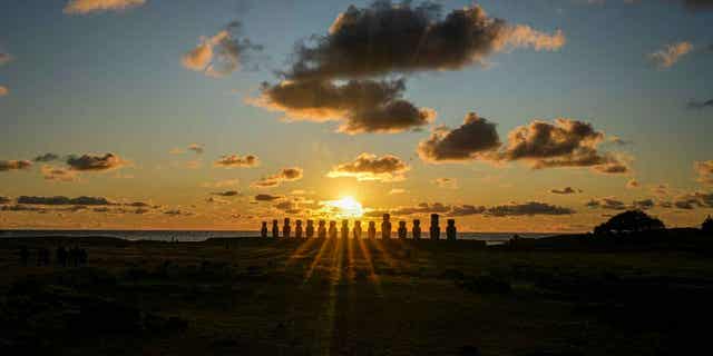 The sun rises behind a line of moai statues on Ahu Tongariki, Easter Island, Chile, on Nov. 26, 2022. The statues were damaged in an October wildfire.