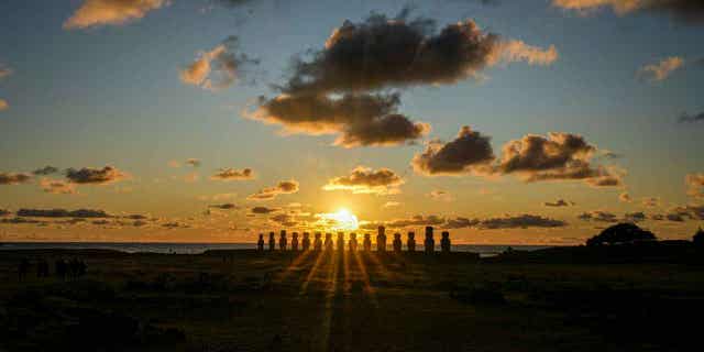 The sun rises behind a line of moai statues on Ahu Tongariki, Easter Island, Chile, on Nov. 26, 2022. The statues were damaged in an October wildfire.