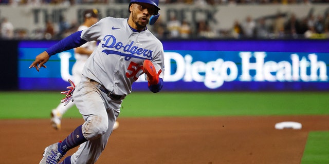 Mookie Betts, #50 of the Los Angeles Dodgers, rounds third base on his way to scoring a run on a sacrifice fly ball hit by Will Smith, #16, during the 7th inning against the San Diego Padres in game four of the National League Division Series at PETCO Park on Oct. 15, 2022 in San Diego.