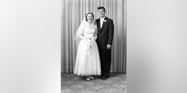 Mr. and Mrs. Doocy on their wedding day. Mrs. Doocy is holding a bouquet of daisies