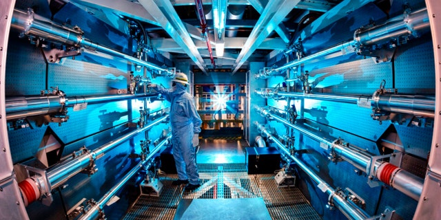 In this 2012 image provided by Lawrence Livermore National Laboratory, a technician reviews an optic inside the preamplifier support structure at the Lawrence Livermore National Laboratory in Livermore, Calif.