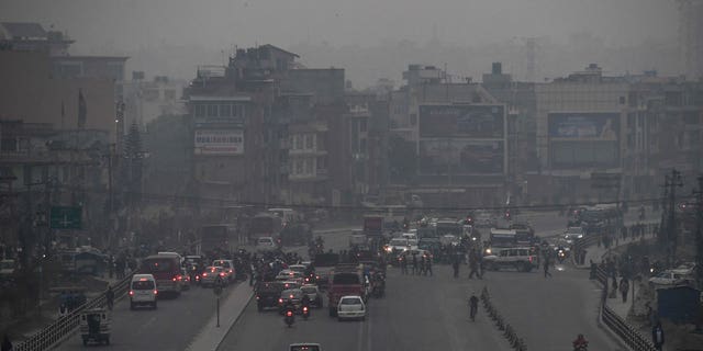 A vehicle in transporting people from a wedding veered off a mountain in Nepal that resulted in 12 dead. There were no survivors in the car. Pictured is commuters making their way along a road amid smoggy conditions in Kathmandu.