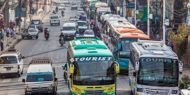 Two road crashes in Nepal have killed at least 17 people and injured 22 others this week.  Pictured are tour buses leaving for Pokhara from Kathmandu, Nepal.