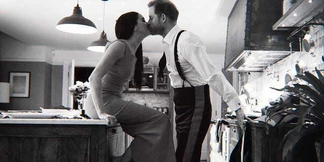 Harry and Meghan kiss in their kitchen in a still from their new Netflix documentary which follows their life as they leave the royal family.