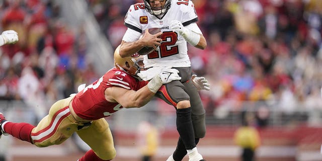 Tampa Bay Buccaneers quarterback Tom Brady tries to elude San Francisco 49ers defensive end Nick Bosa at Levi's Stadium in Santa Clara, California, Dec. 11, 2022.