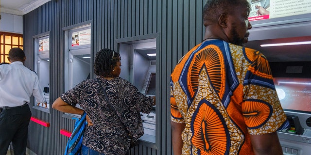 FILE: Customers use automatic teller machines (ATMs) at a United Bank of Africa Plc (UBA) branch in Lagos, Nigeria on Tuesday, Nov. 22, 2022.