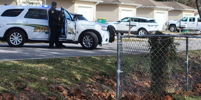 Police cruisers line up outside a Florida home where a deputy was shot and killed on Christmas Eve.