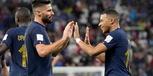 France's Olivier Giroud, left, and Kylian Mbappe celebrate after scoring against Poland, at the Al Thumama Stadium in Doha, Qatar, Sunday, Dec. 4, 2022.