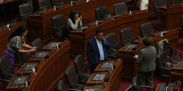 Lawmakers stand inside Congress on the day of their planned impeachment vote on President Pedro Castillo in Lima, Peru, Wednesday, Dec. 7, 2022. (AP Photo/Guadalupe Pardo)