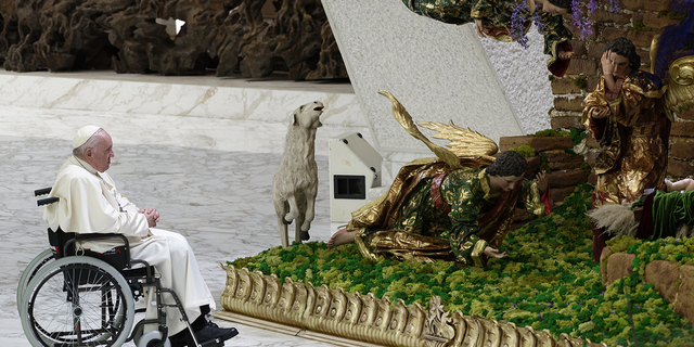 Pope Francis pauses in front of a Nativity scene set up in Paul VI Hall at The Vatican at the end of his weekly general audience, on Dec. 14, 2022.