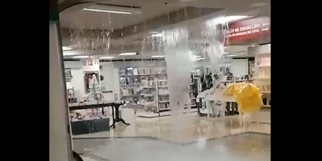 Água da enchente cai do telhado do shopping El Corte Ingles em Lisboa, Portugal, quarta-feira, 7 de dezembro.