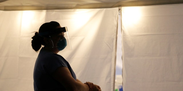 Nurse Jess White stands outside a tent set up to create a drive-through testing clinic for coronavirus, flu and RSV, currently by appointment for employees at UW Medical Center Northwest in Seattle, March 9, 2020. 