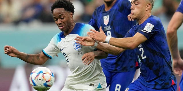 Sergino Dest of USA, right, challenges for the ball with England's Raheem Sterling during the World Cup Group B soccer match between England and USA, at Al Bayt Stadium in Al Khor, Qatar, Friday, November 25, 2022. 