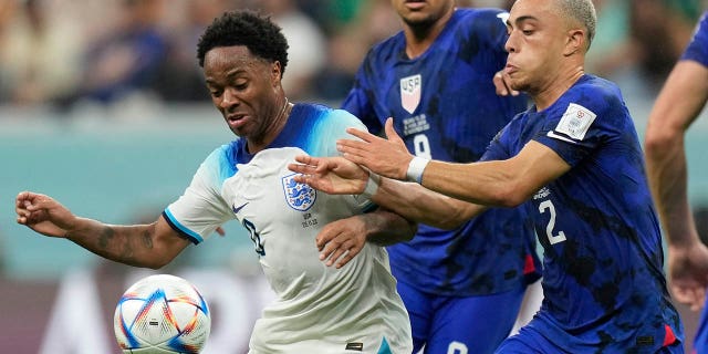 Sergino Dest of the United States, right, challenges for the ball with England's Raheem Sterling during the World Cup group B soccer match between England and The United States, at the Al Bayt Stadium in Al Khor, Qatar, Friday, Nov. 25, 2022. 