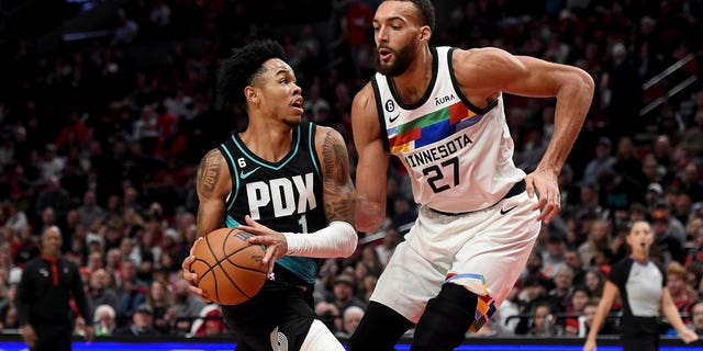 Portland Trail Blazers guard Anfernee Simons, left, drives against Minnesota Timberwolves center Rudy Gobert during the second half of an NBA basketball game in Portland, Oregon, Saturday, Dec. 10, 2022. 