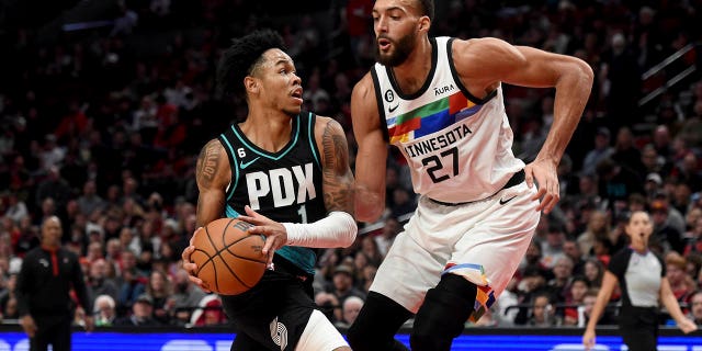 Portland Trail Blazers guard Anfernee Simons, left, drives against Minnesota Timberwolves center Rudy Gobert during the second half of an NBA basketball game in Portland, Oregon, Saturday, Dec. 10, 2022.