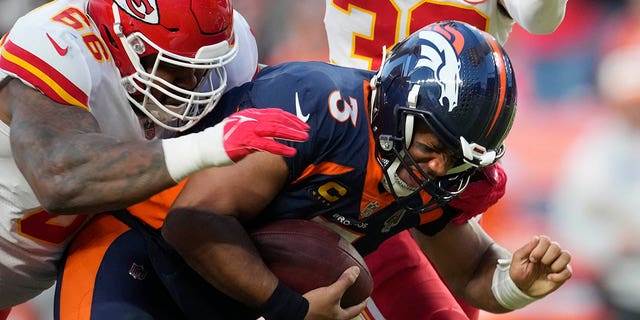 Denver Broncos quarterback Russell Wilson, right, is sacked by Kansas City Chiefs defensive tackle Brandon Williams during the second half, Sunday, Dec. 11, 2022, in Denver.