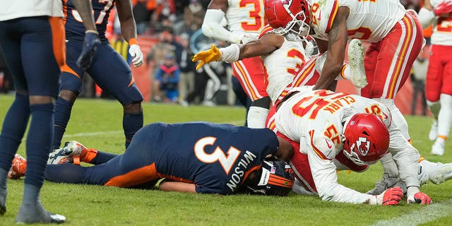 Broncos quarterback Russell Wilson is tackled by Kansas City Chiefs defensive end Frank Clark, Sunday, Dec. 11, 2022, in Denver.