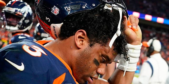 Broncos quarterback Russell Wilson removes his helmet after receiving a concussion during the Kansas City Chiefs game, Sunday, Dec. 11, 2022, in Denver.