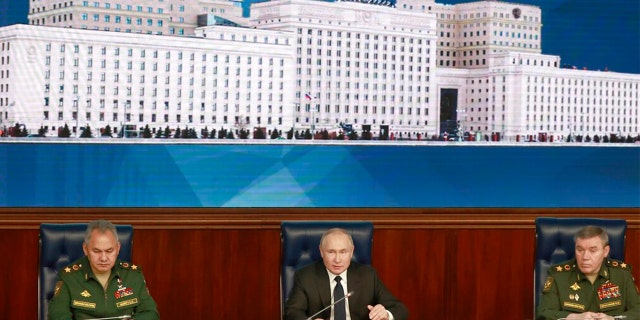 Russian President Vladimir Putin, center, speaks as Russian Defense Minister Sergei Shoigu, left, and Chief of the General Staff Gen. Valery Gerasimov attend a meeting with senior military officers in Moscow, Russia, Wednesday, Dec. 21, 2022. 