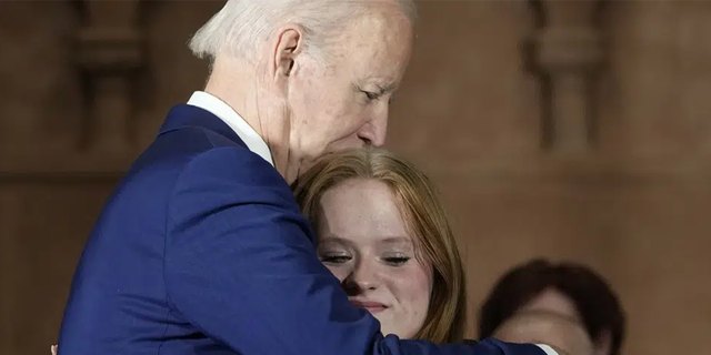 President Joe Biden hugs Sandy Hook survivor Jackie Hegarty, who introduced him, during an event in Washington, Wednesday, Dec. 7, 2022, with survivors and families impacted by gun violence for the 10th Annual National Vigil for All Victims of Gun Violence.