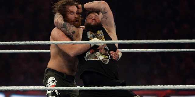 Sami Zayn, left, receives a Stunner from Kevin Owens during WrestleMania 37 at Raymond James Stadium on April 11, 2021 in Tampa, Florida.