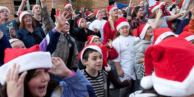 People in the crowd reach out to try to grab the free T-shirts that are thrown during the event. The city of Brockton competes for the largest number of people wearing Santa hats in one place in downtown Brockton, Massachusettes, on Sunday, Nov. 20, 2011. 